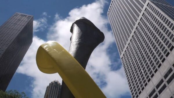 Close up of a yellow phone wrapped around a bone with skyscrapers behind it