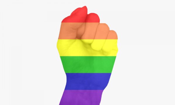 A hand raised in a fist covered in a rainbow overlay