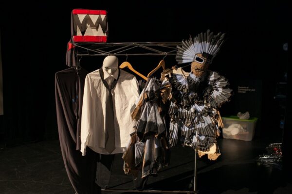 Costumes on a rack in a dark room