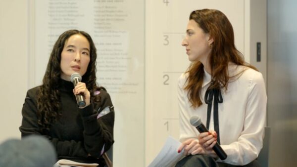 Two female-presenting people holding microphones