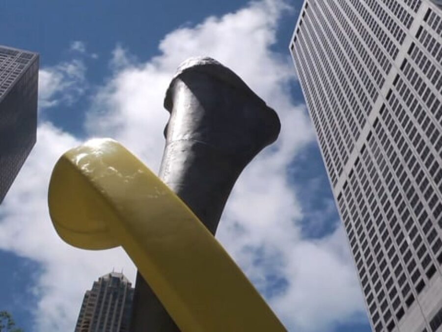 Close up of a yellow phone wrapped around a bone with skyscrapers behind it