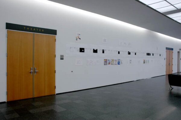 Small artworks hang on a white wall between two sets of double doors