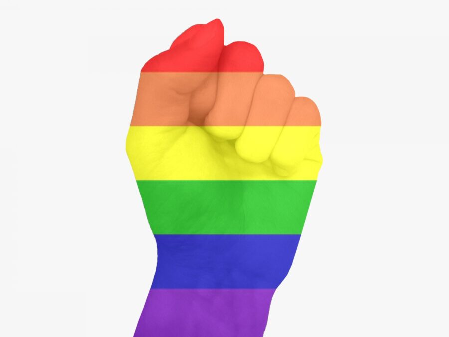 A hand raised in a fist covered in a rainbow overlay