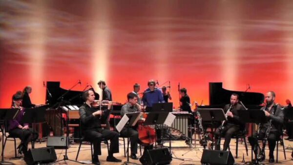 A classical band on a stage with a sunset backdrop