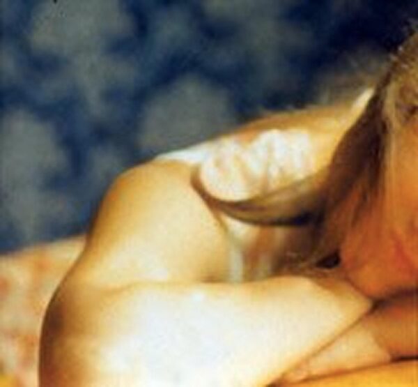 A cropped image of a person lying down, only their bent right arm fully showing
