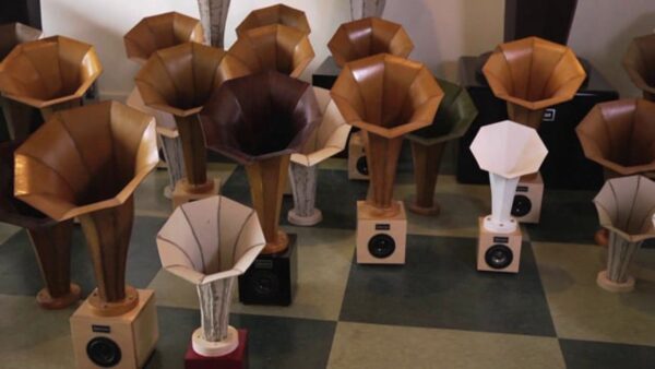 Various sized speakers on a black and white tile floor