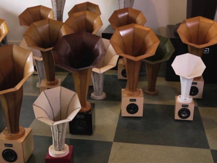 Various sized speakers on a black and white tile floor