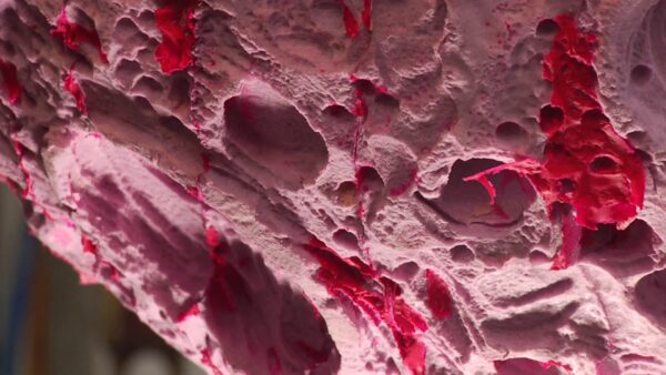 Close up of a heavily textured pink object with hot pink accents throughout