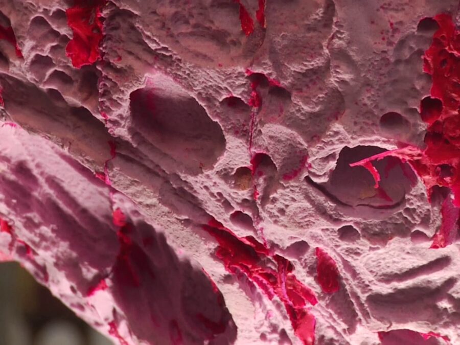 Close up of a heavily textured pink object with hot pink accents throughout