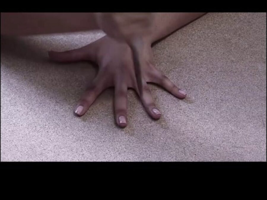 Still of a hand on a surface with fingers splayed and a knife between the middle and ring fingers
