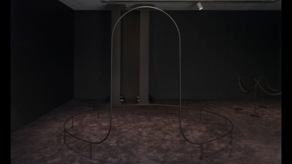 A dark room with a black arched sculpture