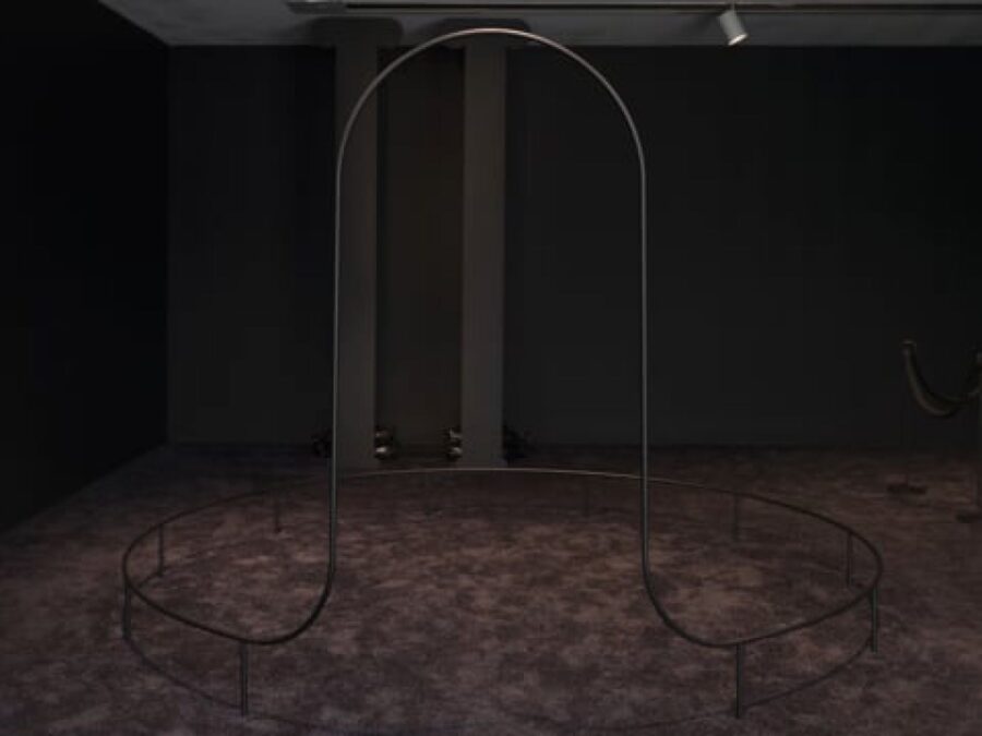 A dark room with a black arched sculpture