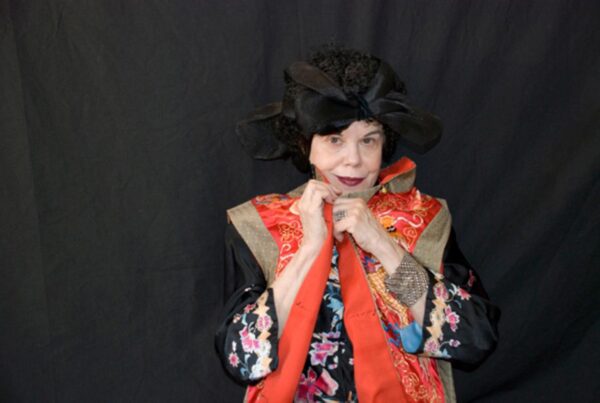 Portrait of a person in colorful red clothes against a black background