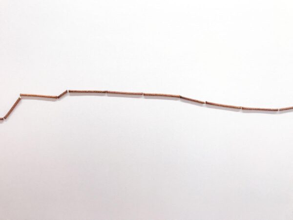 An uneven line of pretzel rods against a white background