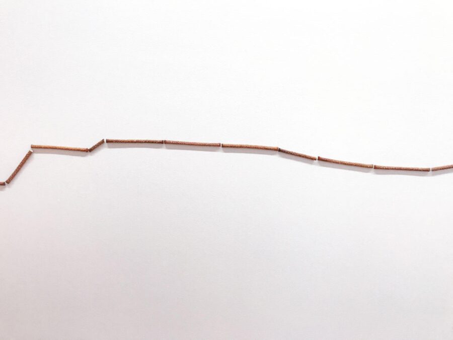 An uneven line of pretzel rods against a white background