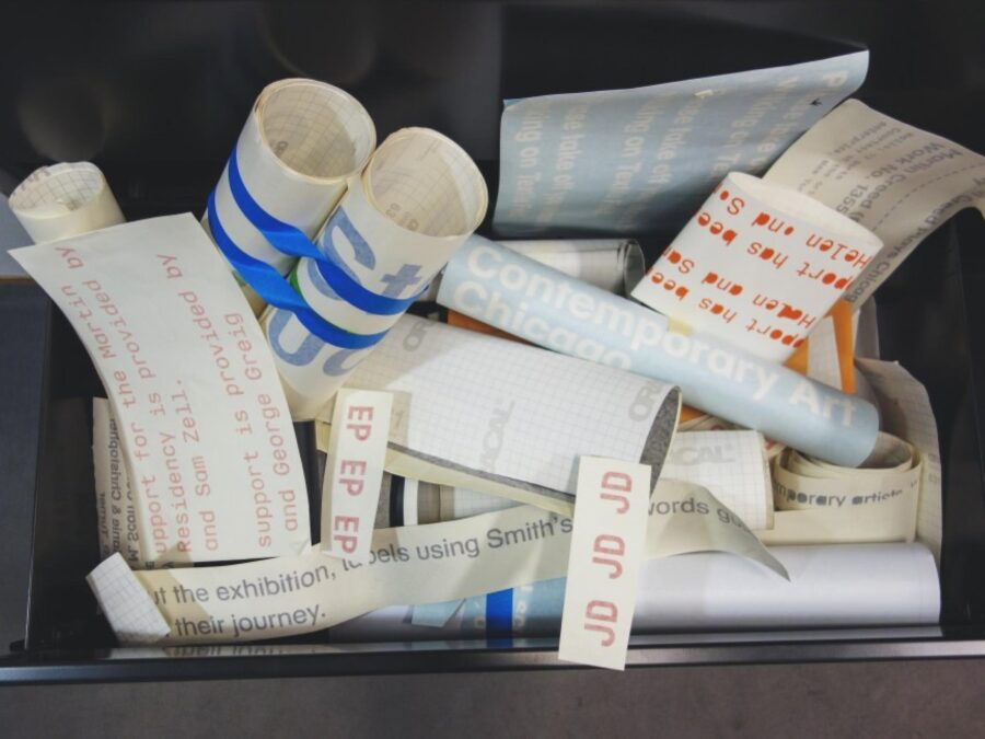 Rolls of vinyl letters in a storage bin