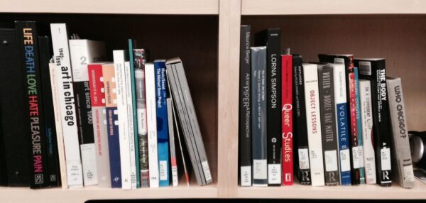 Two cubbies filled with art-related books with library call number stickers on them
