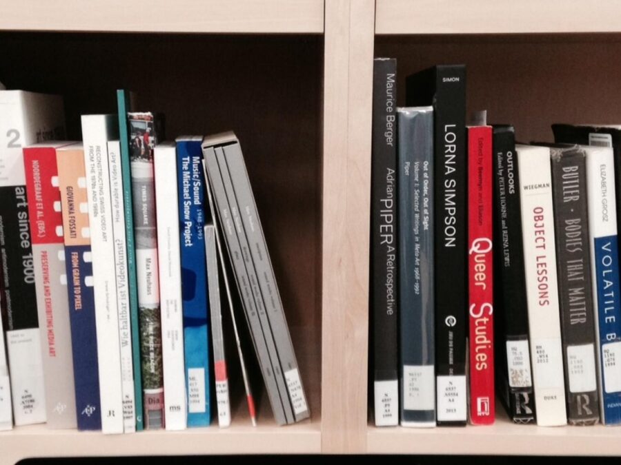 Two cubbies filled with art-related books with library call number stickers on them
