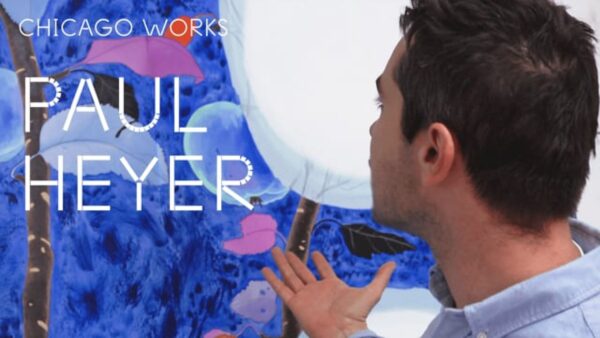 A person with short brown hair and light skin gestures with their right hand toward a large blue and white painting. Over the image, white text reads Paul Heyer.