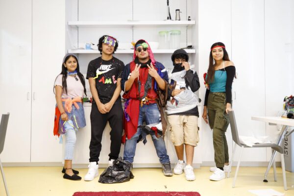 Five teens pose modeling their clothes
