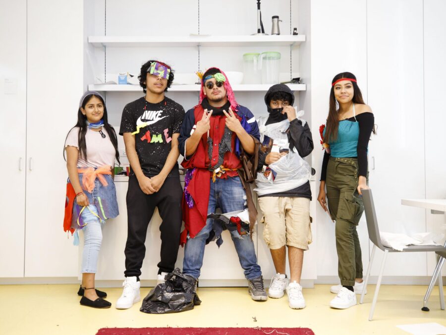 Five teens pose modeling their clothes