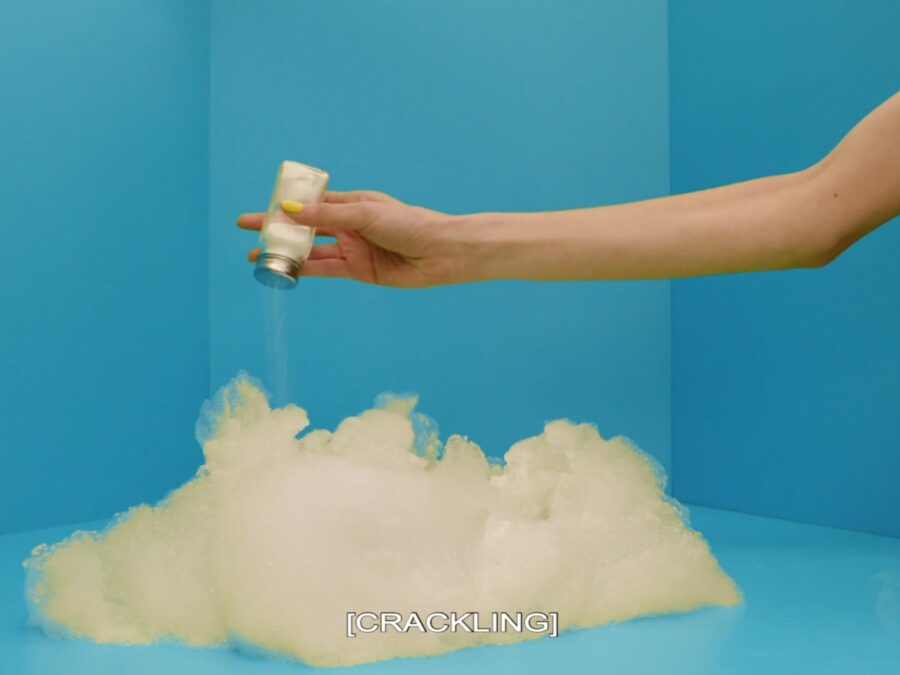 An arm extends into a blue room, shaking salt onto a cloud-like mass. Text on the image says [CRACKLING].