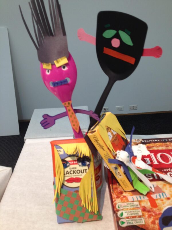Plastic spoons and cardboard packaging all with paper faces on them