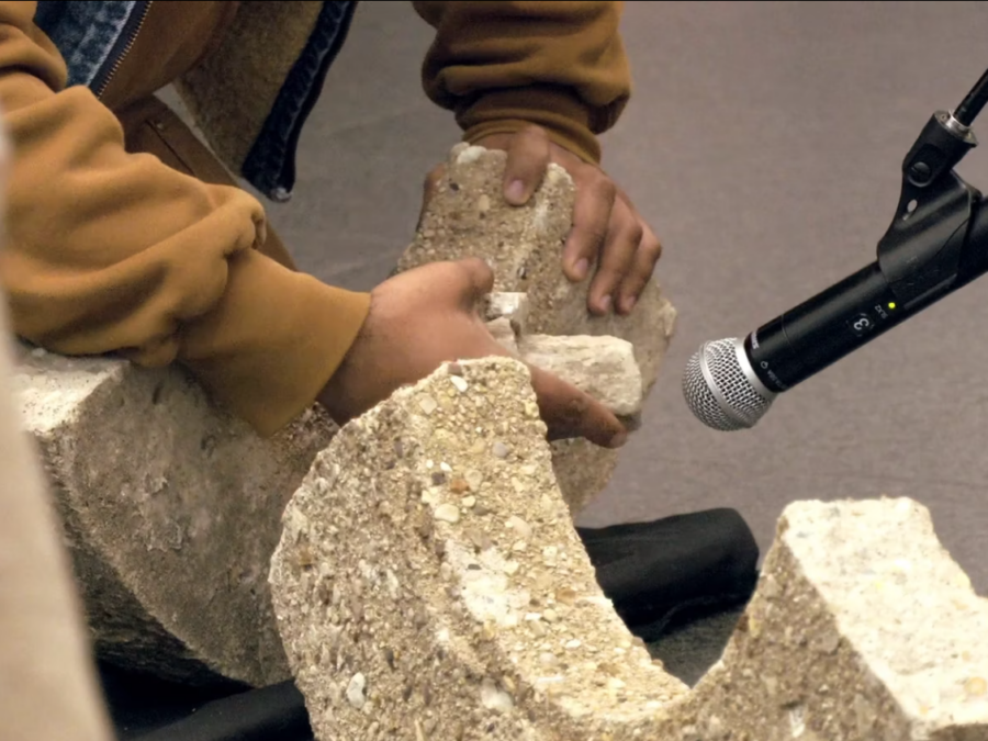 A close up of a person holding broken pieces of concrete up to a microphone