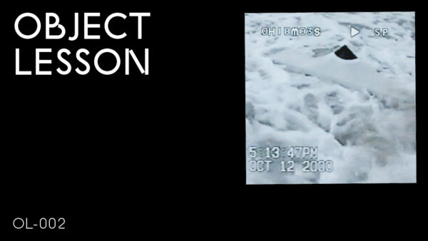 A black rectangle with the words Object Lesson in the upper left hand corner and OL 002 in the bottom left hand corner accompanied by a blue-gray image in the upper right hand corner