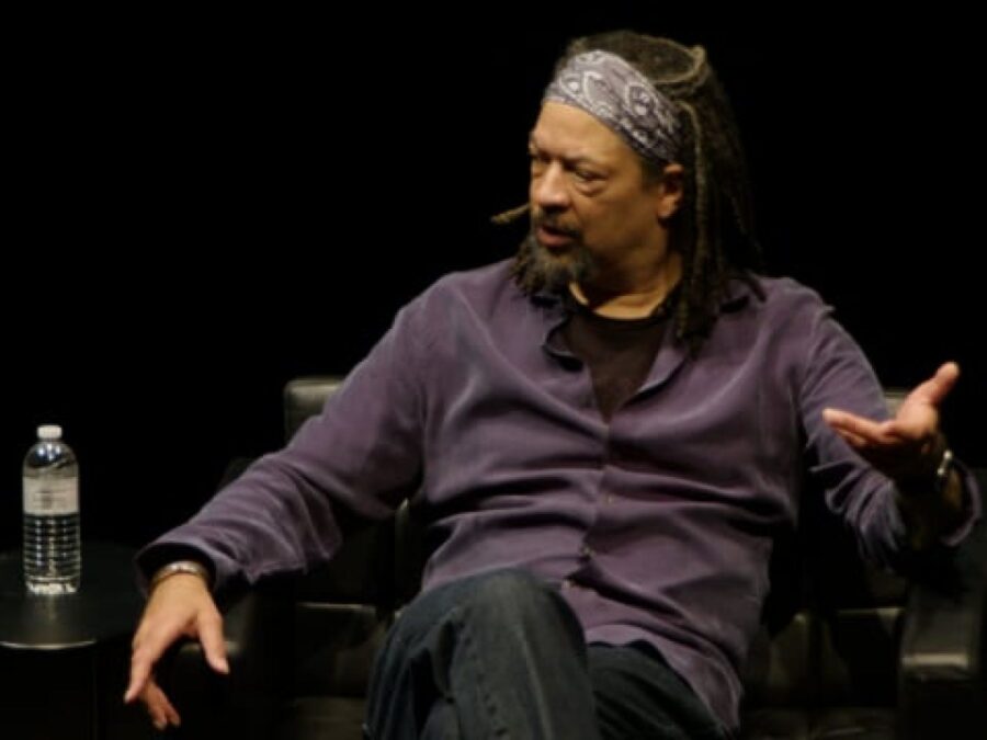 A man sits in a chair on a black stage