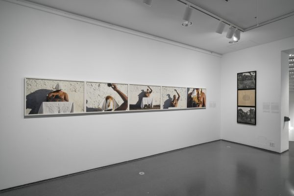 Corner of gallery with two artworks hanging on the wall.