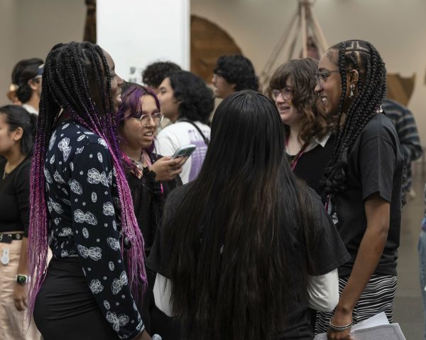 A crowd of people gathered together in various smaller groups.