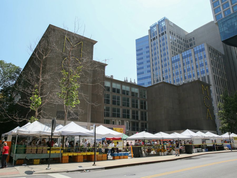 The MCA's plaza covered with pop-up white vendor tents filled with flowers and produce.