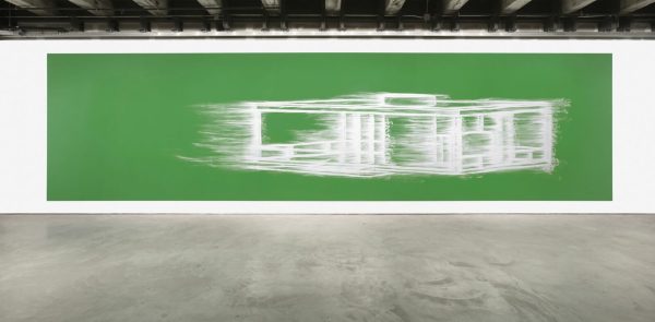 A large green artwork with a smeared white architectural design hangs on a white wall in an industrial space.