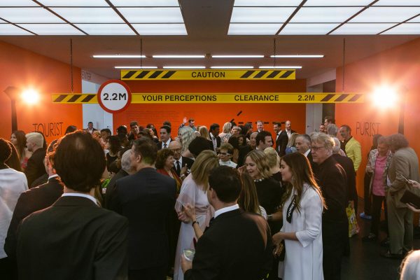 A crowd of people in a room filled with hazard signs