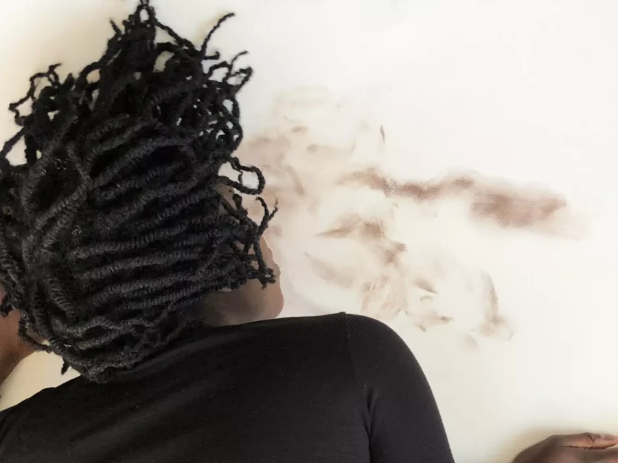 Person lays sprawled against smudges on a wall