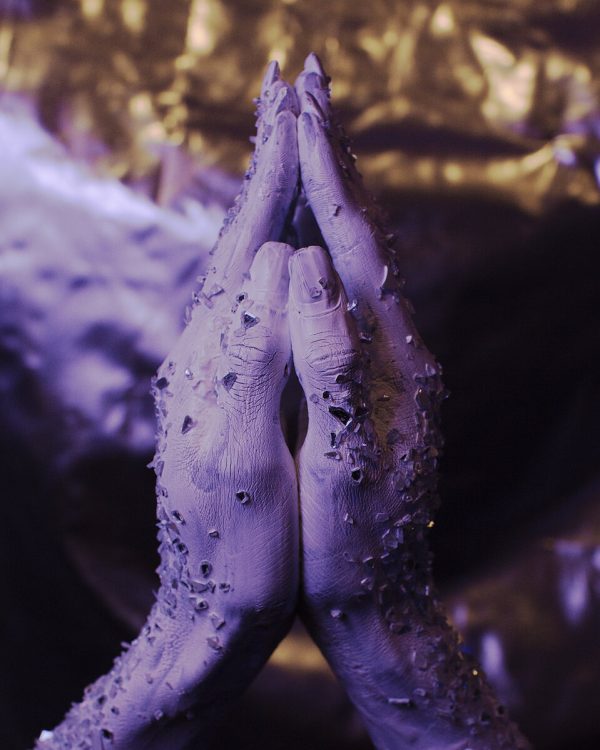 Two purple hands are shown palms together; nothing else is identifiable.