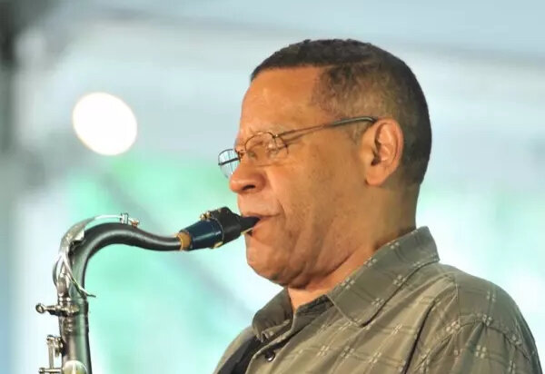 Candid shot of a man turned to the left playing the saxaphone.
