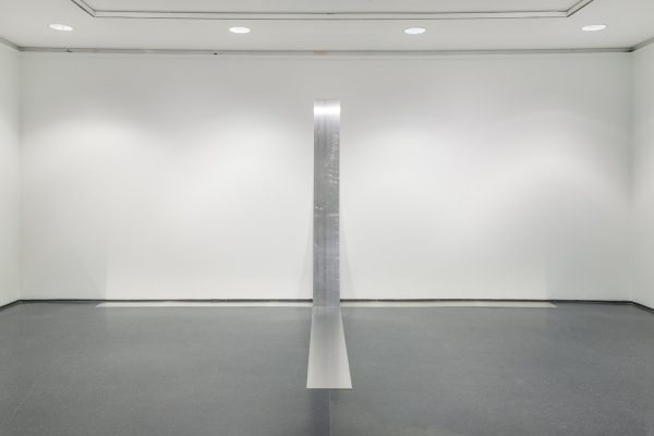 Thin sheets of metal are placed against the wall and flat on the floor to form almost a plus-sign form.