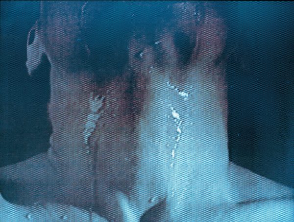 Grainy blue image of a person's neck with liquid running down it seen from close up