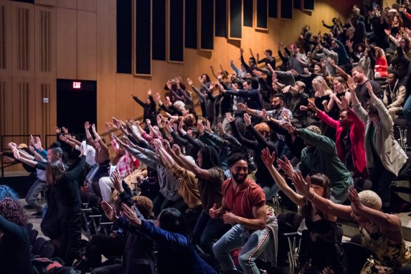Photo of audience members raising their hands.