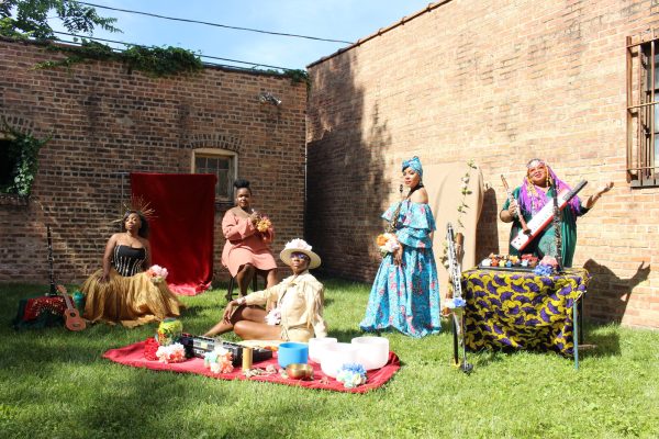 Five woman post in a yard surrounded by brick walls.