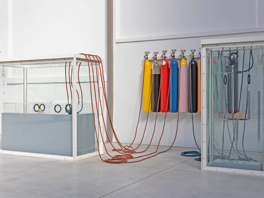 Tanks filled with a liquid are connected by wires and multicolored gas tanks.