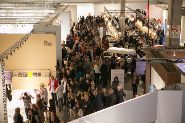 An overhead view of a crowd of people in a large, warehouse-type space.