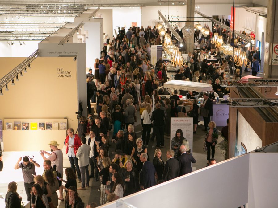 An overhead view of a crowd of people in a large, warehouse-type space.