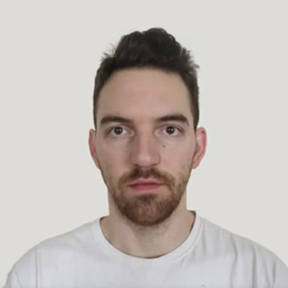 Stark portrait of a male-presenting person with light skin, short dark hair, and a goatee in a white t-shirt against a white background