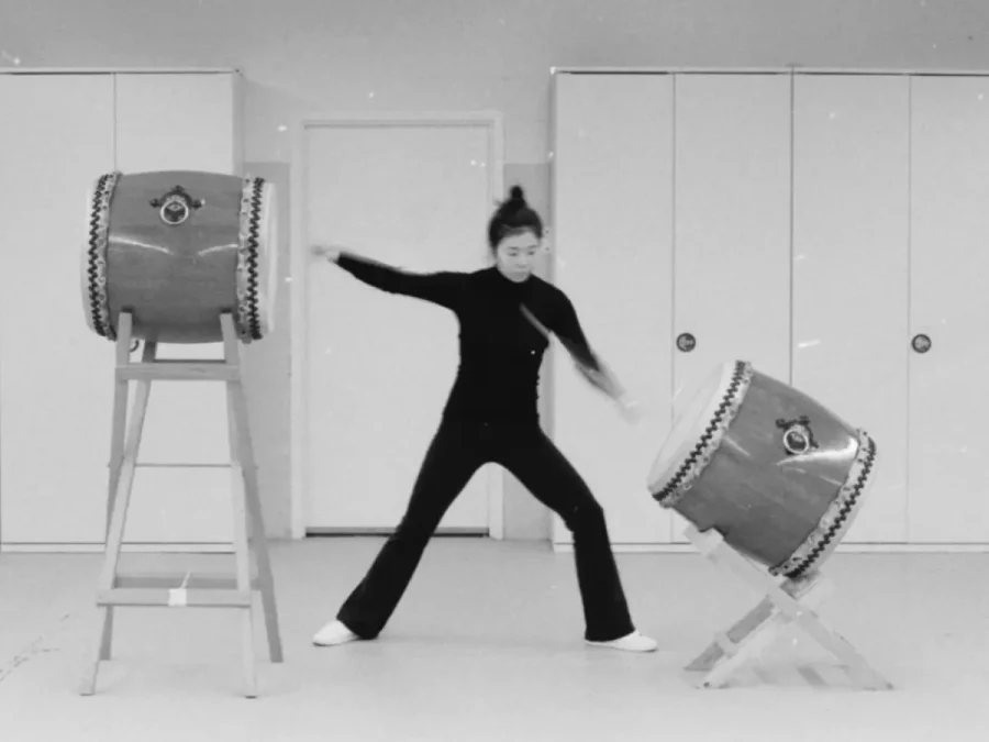 Kioto Aoki striking two large upright drums