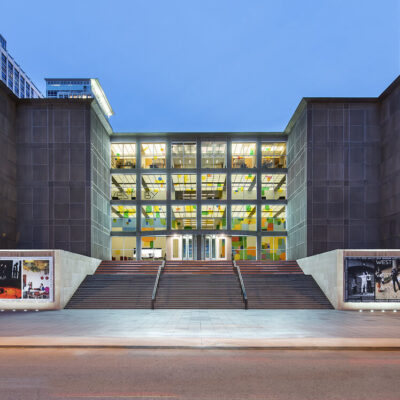 The MCA building front with all four rows of windows lit up.