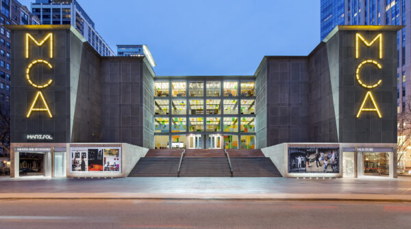 The MCA building front with all four rows of windows lit up.