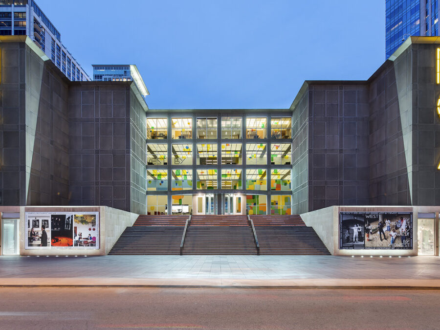 The MCA building front with all four rows of windows lit up.